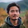 用户纪录片爱好者阿哲的头像，年轻男性若有所思，背景为自然风光