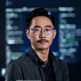91视频网站算法工程师赵明轩的职业照，年轻技术专家形象，背景为代码屏幕